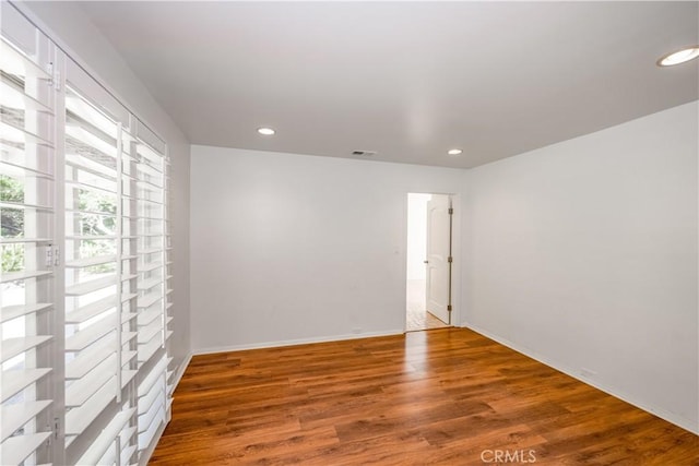 empty room with recessed lighting, visible vents, and wood finished floors