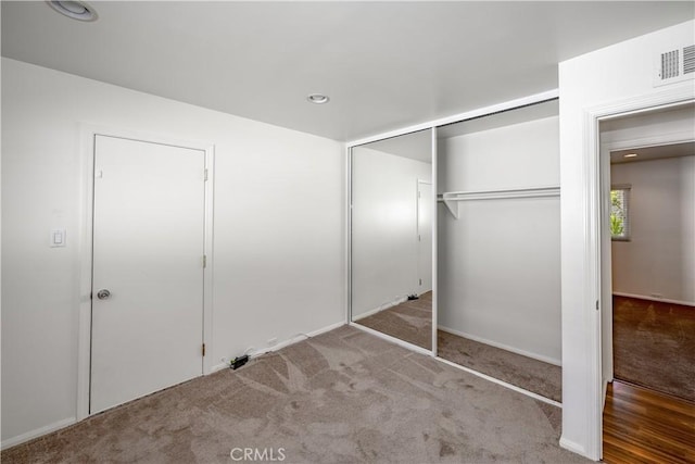 unfurnished bedroom featuring carpet floors, a closet, visible vents, and recessed lighting