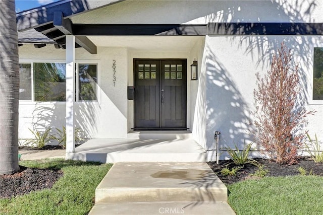 entrance to property featuring stucco siding