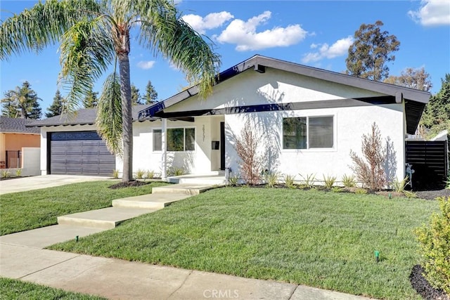 ranch-style home featuring an attached garage, a front yard, concrete driveway, and stucco siding