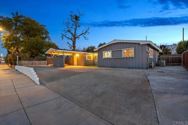 single story home with board and batten siding, driveway, and fence