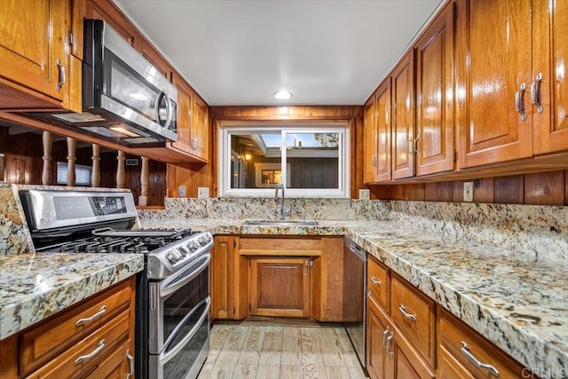 kitchen with a sink, appliances with stainless steel finishes, and brown cabinets