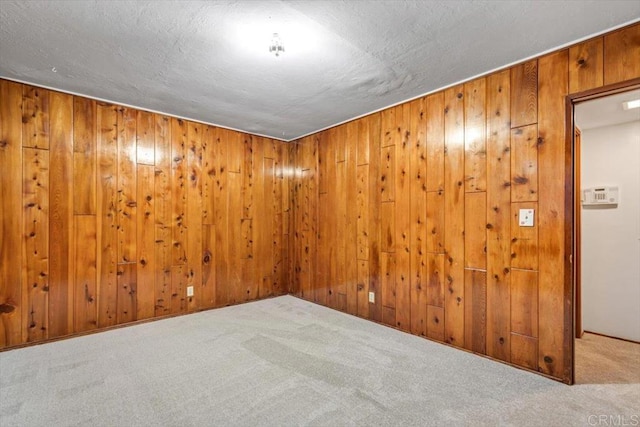 carpeted spare room with wooden walls