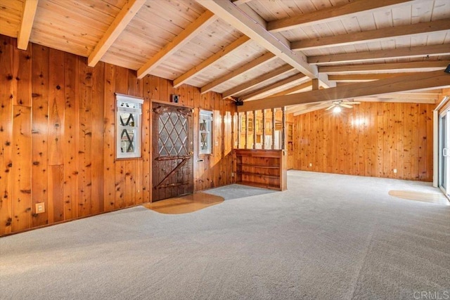 empty room featuring wooden ceiling, carpet flooring, wooden walls, and vaulted ceiling with beams