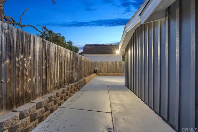 property exterior at dusk with a patio and a fenced backyard