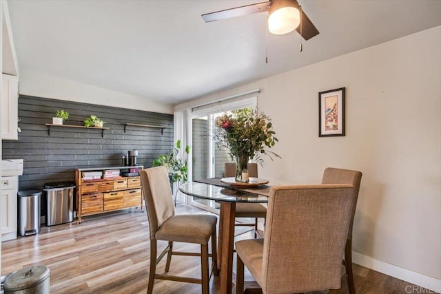 dining room with light wood-type flooring, ceiling fan, and baseboards