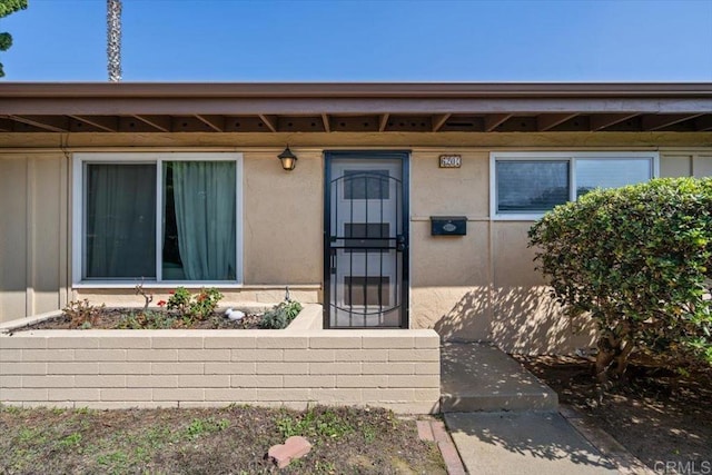 property entrance with stucco siding