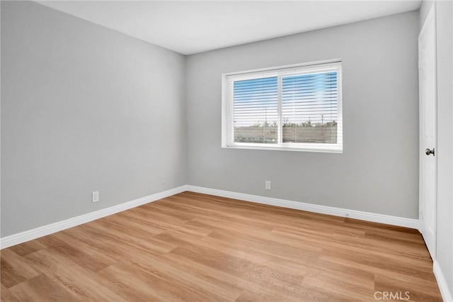 spare room with light wood-style flooring and baseboards