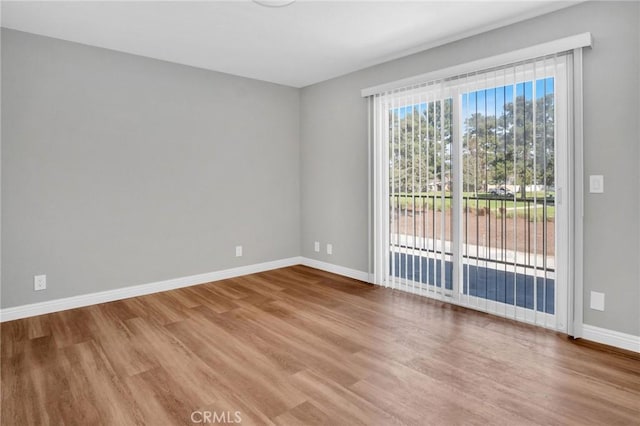 unfurnished room featuring baseboards and wood finished floors