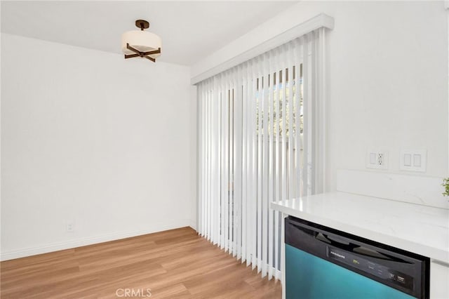 interior space featuring baseboards and light wood finished floors