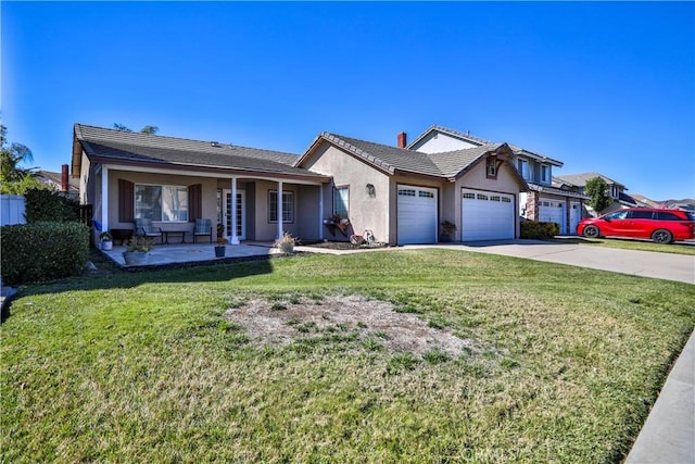 view of front of house featuring a garage, a tile roof, concrete driveway, stucco siding, and a front lawn