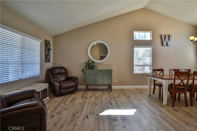 living area featuring lofted ceiling, light wood-style floors, and baseboards