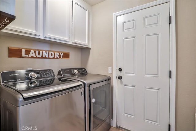 washroom featuring independent washer and dryer and cabinet space