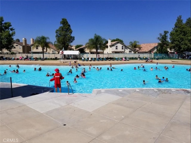 community pool with fence and a patio