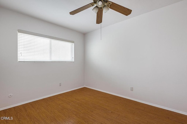 empty room featuring ceiling fan, baseboards, and wood finished floors