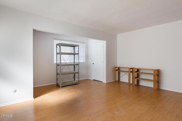 empty room with light wood-style flooring and baseboards