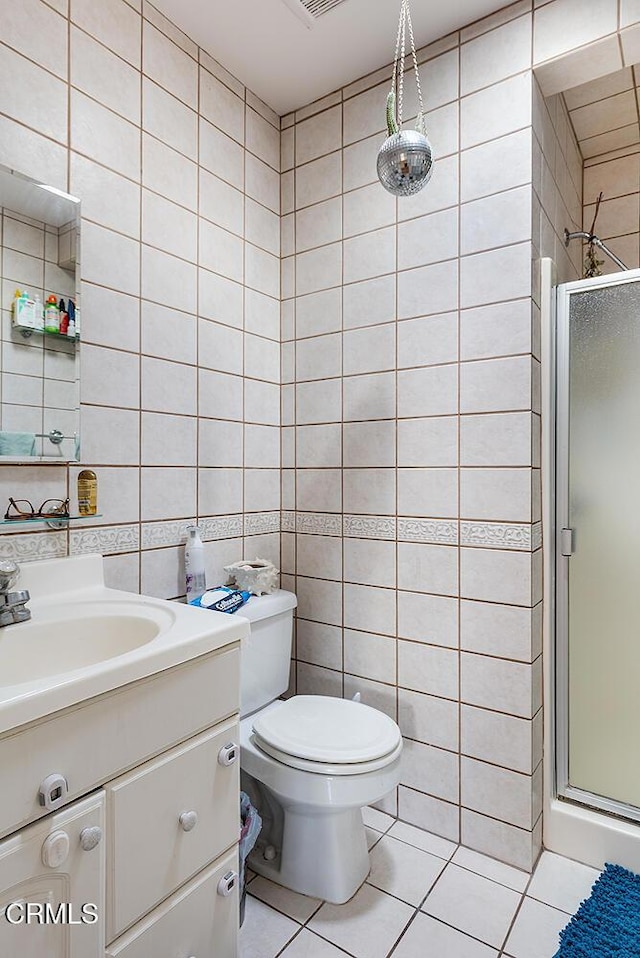 full bathroom featuring tile walls, a shower stall, vanity, and tile patterned floors