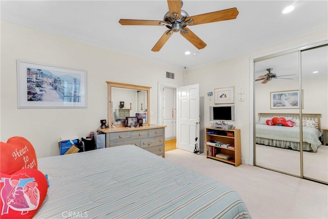 bedroom with recessed lighting, light colored carpet, a ceiling fan, visible vents, and a closet