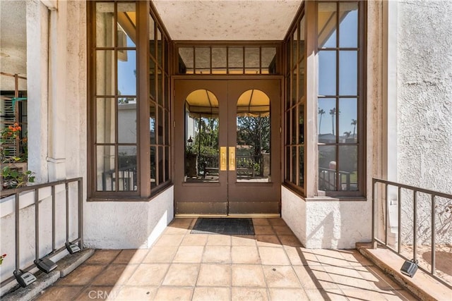 property entrance featuring french doors and stucco siding