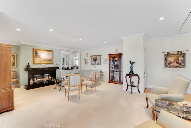 living room with carpet floors, ornamental molding, a glass covered fireplace, and recessed lighting