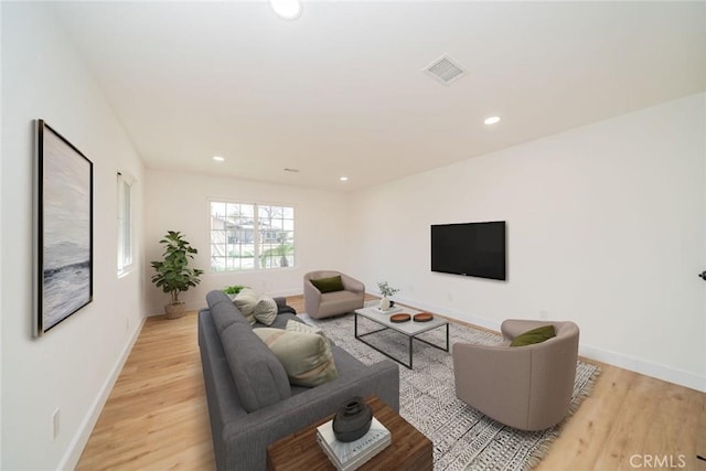 living room featuring light wood-type flooring, visible vents, baseboards, and recessed lighting