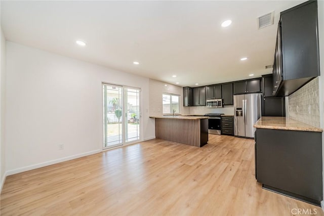 kitchen with light wood finished floors, visible vents, appliances with stainless steel finishes, a peninsula, and recessed lighting