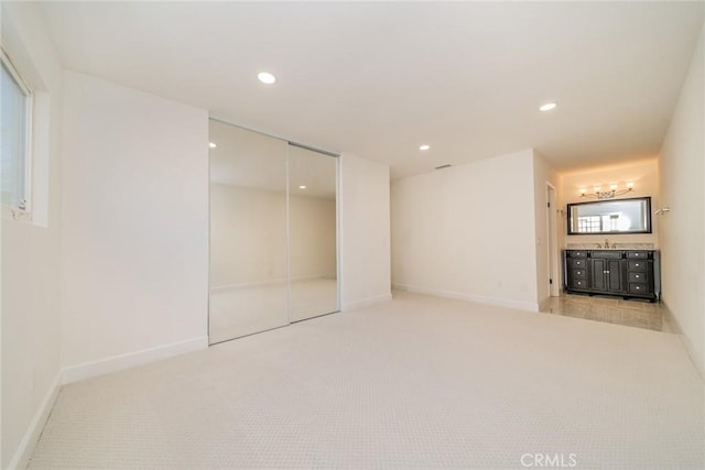 unfurnished bedroom featuring a sink, baseboards, carpet flooring, and recessed lighting