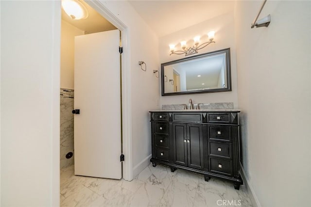 bathroom with marble finish floor, vanity, and baseboards