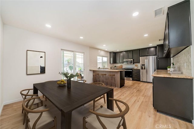 dining space with light wood-style floors, baseboards, visible vents, and recessed lighting