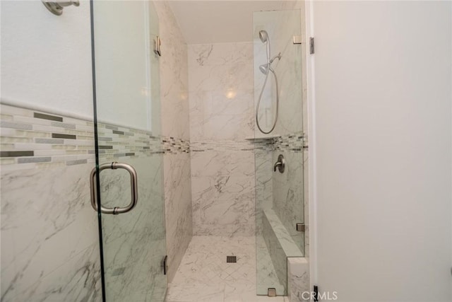 bathroom featuring a marble finish shower