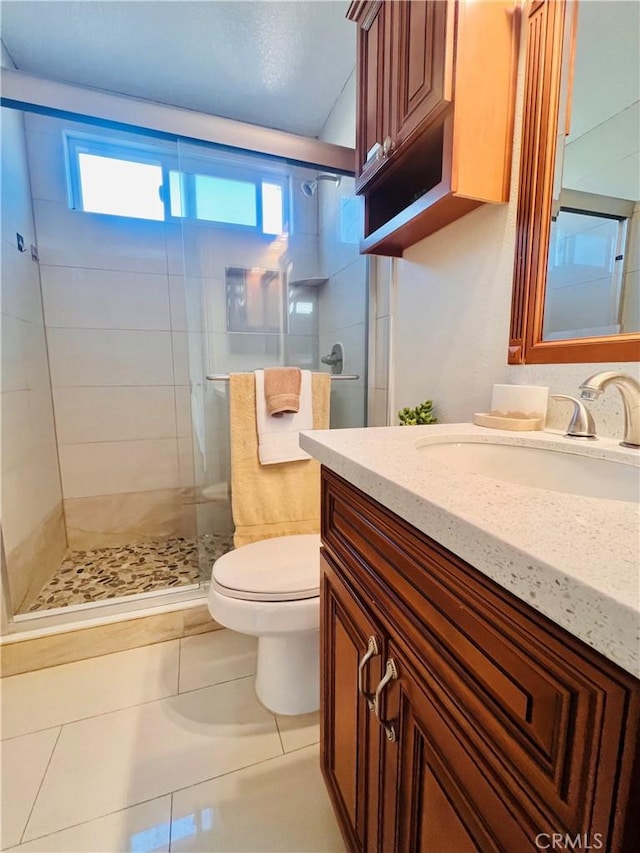 bathroom with vanity, a stall shower, tile patterned flooring, and toilet