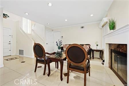 living area with visible vents, a premium fireplace, ornamental molding, light tile patterned flooring, and recessed lighting