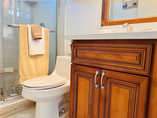 bathroom with a stall shower, vanity, and toilet