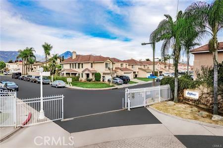 view of street featuring a gated entry, a gate, a residential view, and curbs