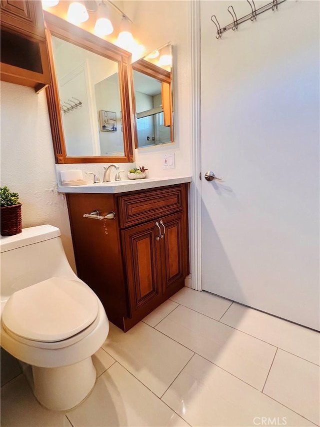 bathroom with toilet, tile patterned floors, and vanity