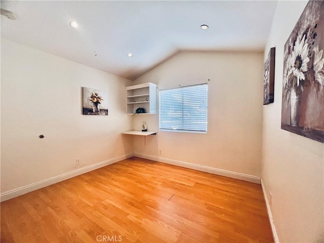 unfurnished room with vaulted ceiling, recessed lighting, light wood-style flooring, and baseboards