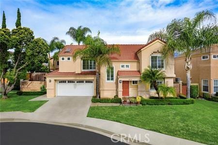 mediterranean / spanish-style home featuring a tile roof, stucco siding, a front yard, a garage, and driveway