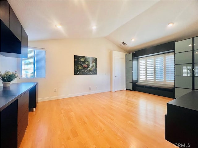 living area featuring lofted ceiling, recessed lighting, visible vents, light wood-style floors, and baseboards