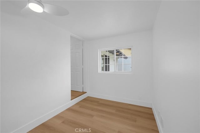 empty room featuring light wood-style flooring, baseboards, and a ceiling fan