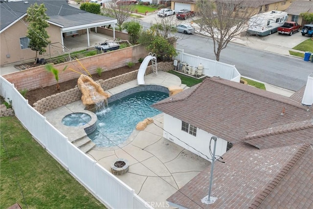 view of pool featuring a water slide, a fenced backyard, a yard, a fenced in pool, and a patio area