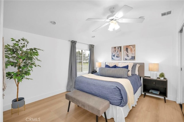 bedroom with baseboards, a ceiling fan, visible vents, and light wood-style floors