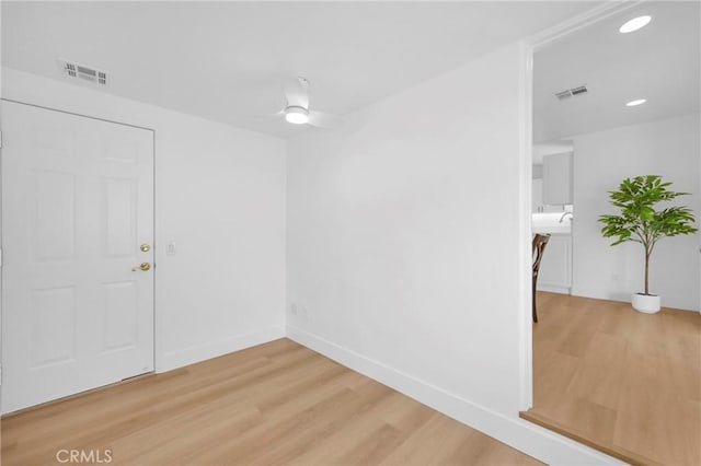 spare room featuring light wood-style floors, baseboards, visible vents, and recessed lighting