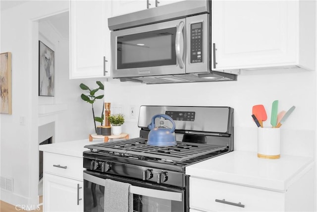 kitchen with light countertops, appliances with stainless steel finishes, and white cabinets