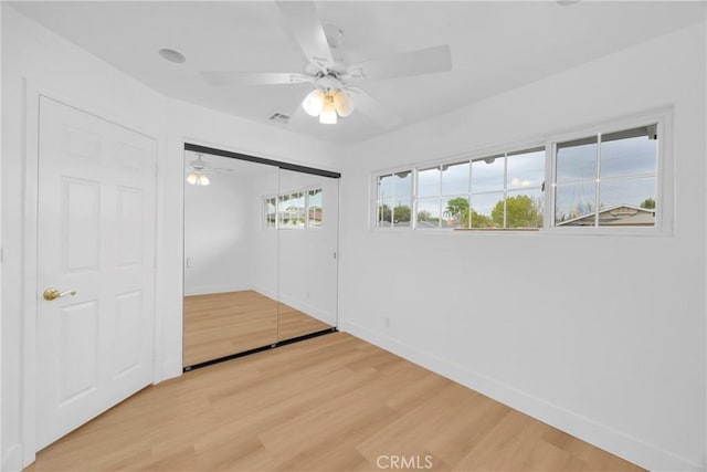 interior space featuring light wood-style floors, visible vents, baseboards, and a ceiling fan