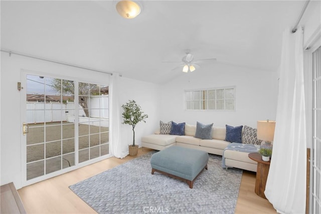 living room with a ceiling fan, lofted ceiling, and wood finished floors