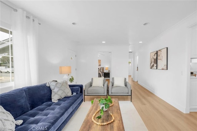 living area featuring light wood-type flooring, crown molding, baseboards, and recessed lighting