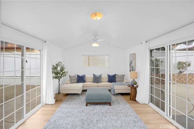 living room featuring lofted ceiling, plenty of natural light, a ceiling fan, and wood finished floors