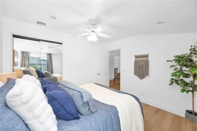 bedroom with visible vents, ceiling fan, baseboards, and wood finished floors