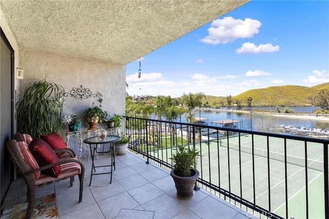 balcony featuring a water and mountain view