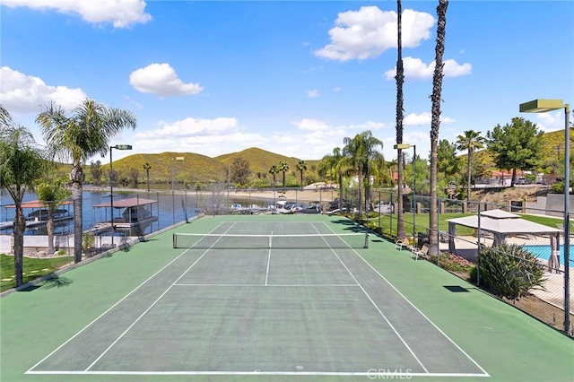 view of sport court featuring fence and a mountain view